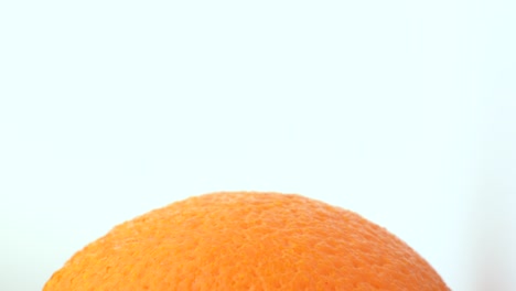 fruta naranja girando en la mesa giratoria. aislado en fondo blanco. macro de cerca. vista en ángulo girado.