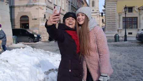 two young smiling women tourists bloggers taking selfie photos portrait, video conferencing call