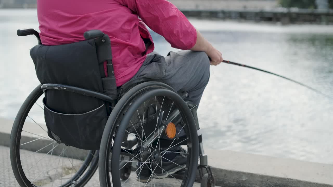 persona con discapacidad física que utiliza silla de ruedas para pescar en el muelle de pesca