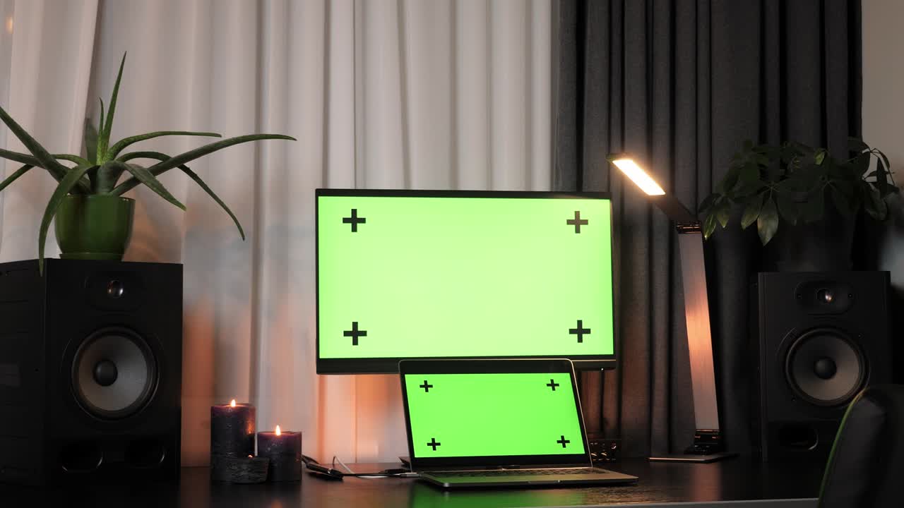 책상, 노트북 및 컴퓨터와 함께 모의 녹색 화면 디스플레이를 가진 홈 오피스의 인테리어.