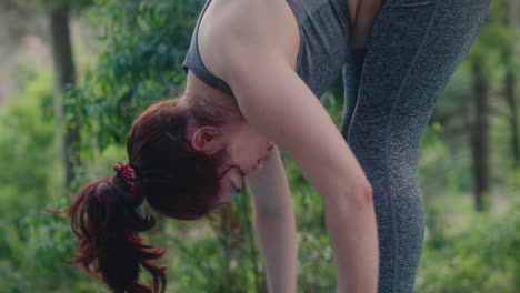 chica practica yoga en un bosque hacia adelante plegado movimiento tiro de cerca