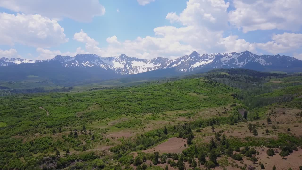 Aerial sweep arcross high plateau to San Juan Mountains in CO Rockies