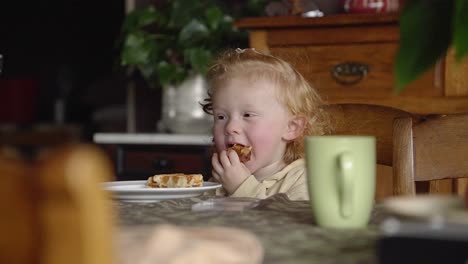 toddler eating a waffle in the vintage dining room of grandmother, sitting at the table