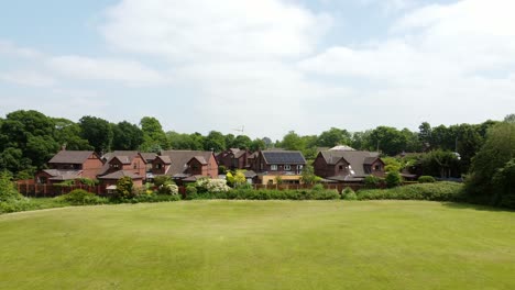 Aerial-view-rising-over-red-brick-new-home-townhouse-development-on-luxury-suburban-woodland-real-estate-neighbourhood