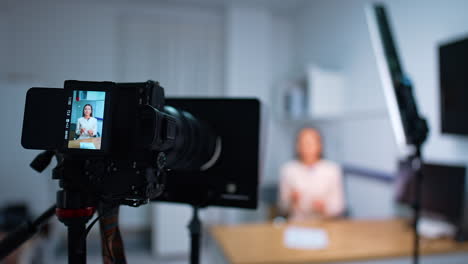 working professional camera with a woman at display. close up. blog content creation. blurred backdrop.