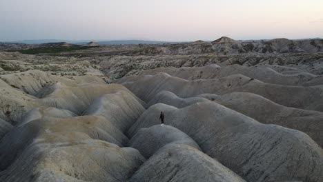 Drone-shot-of-an-explorer-standing-alone-in-the-Mahoya-Desert-in-Spain