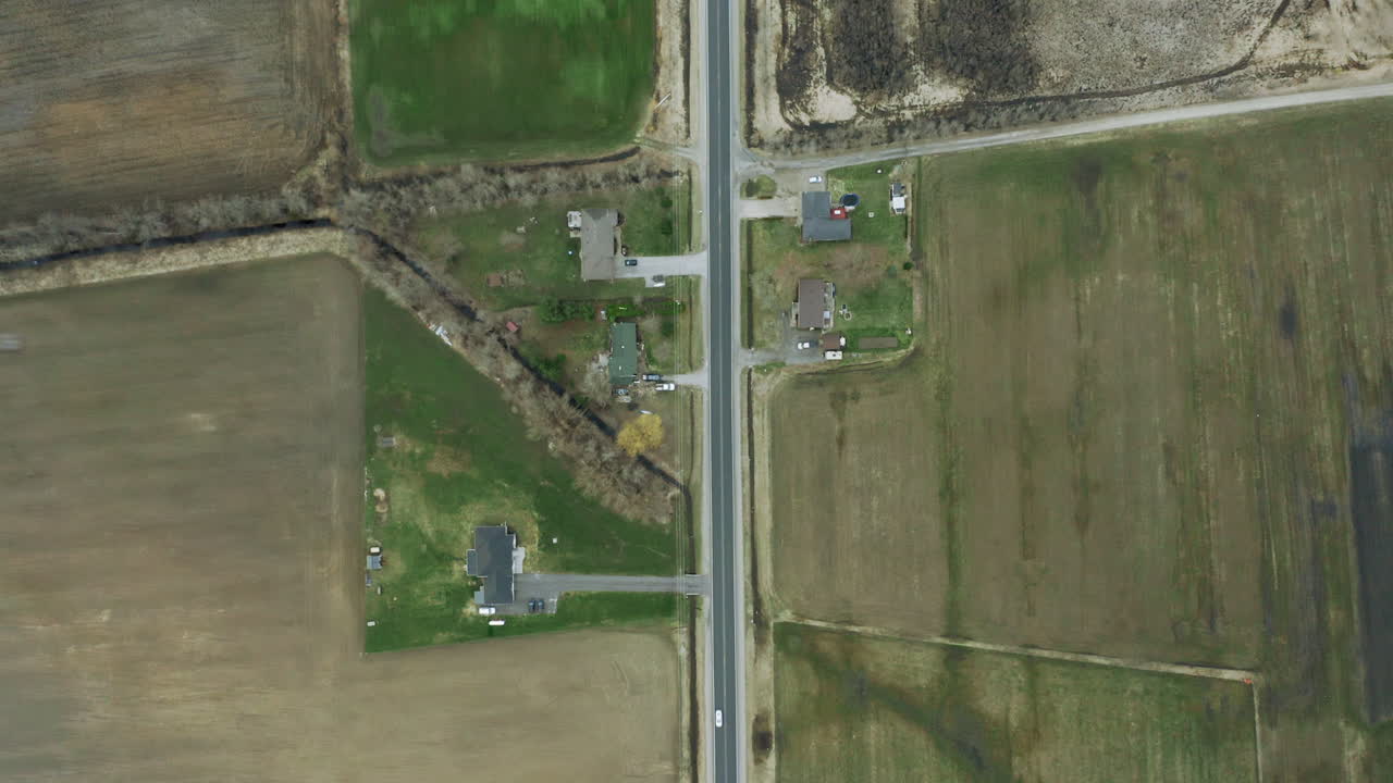 carretera de campo delgada con carreteras que conducen por el camino con enormes campos agrícolas a cada lado