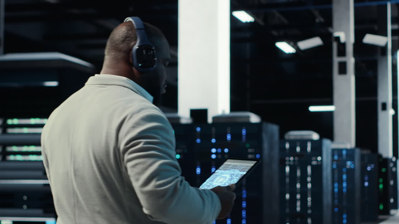 Vertical video Admin walking in data center, listening music while doing inspection