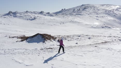 woman walking alone in mountains covered with snow