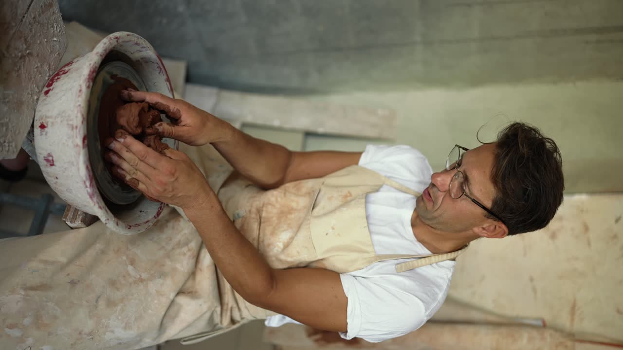 un joven alfarero feliz con gafas está bailando con un pincel en la mano. tiempo feliz sosteniendo. logrando el éxito