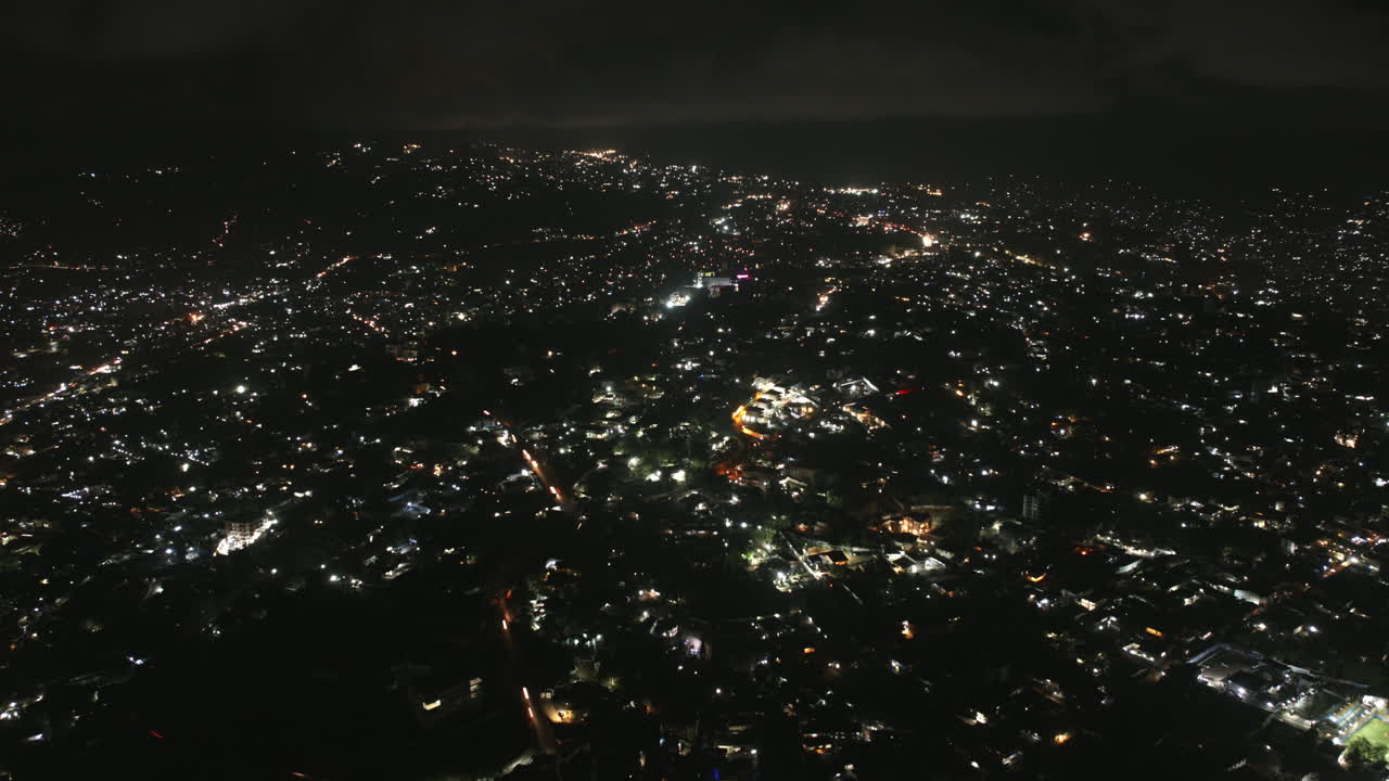 Wide aerial hyperlapse of the city of Freetown, Sierra Leone at night with traffic.
