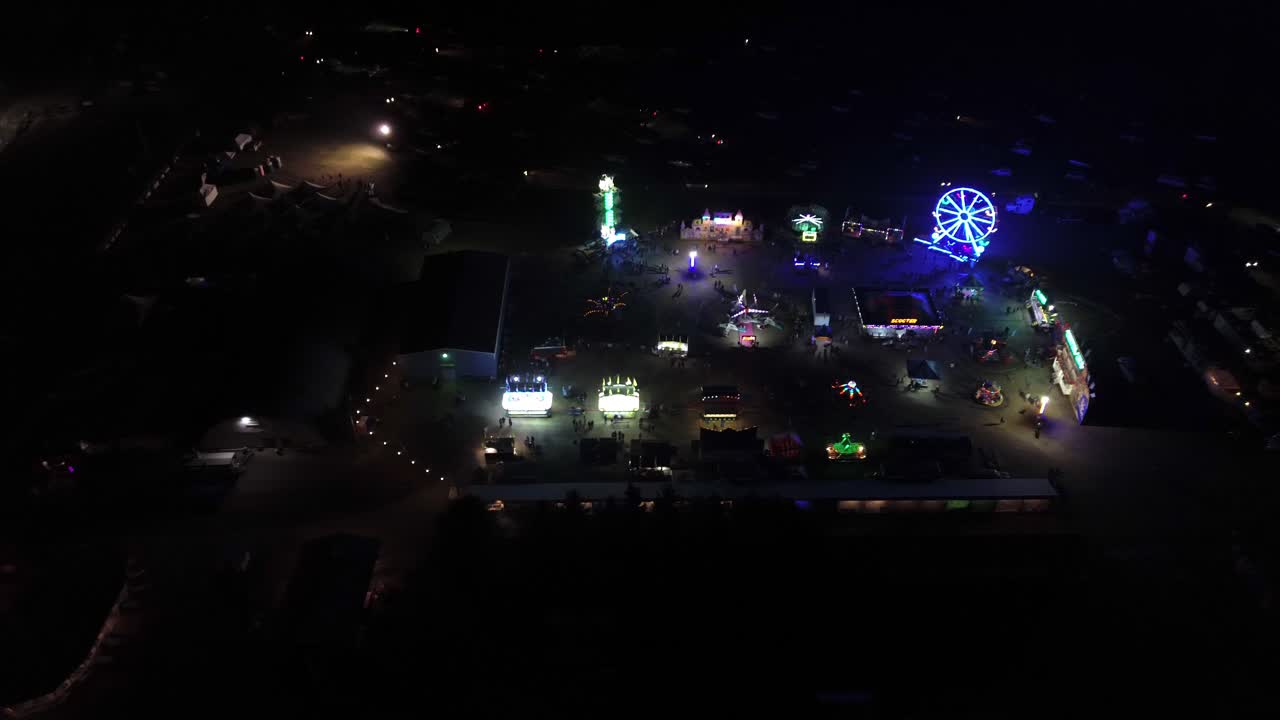 el recinto ferial de bulkley valley por la noche con luces de neón intermitentes de colores de un dron aéreo que se desplaza por encima