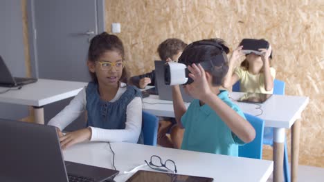 excited schoolchildren putting on vr headset