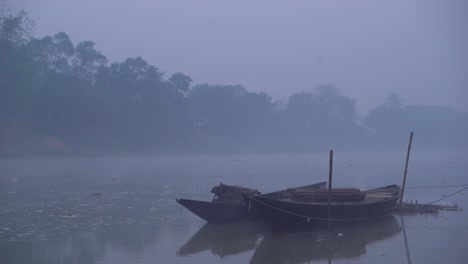 there are boats tied to the river at dawn of winter