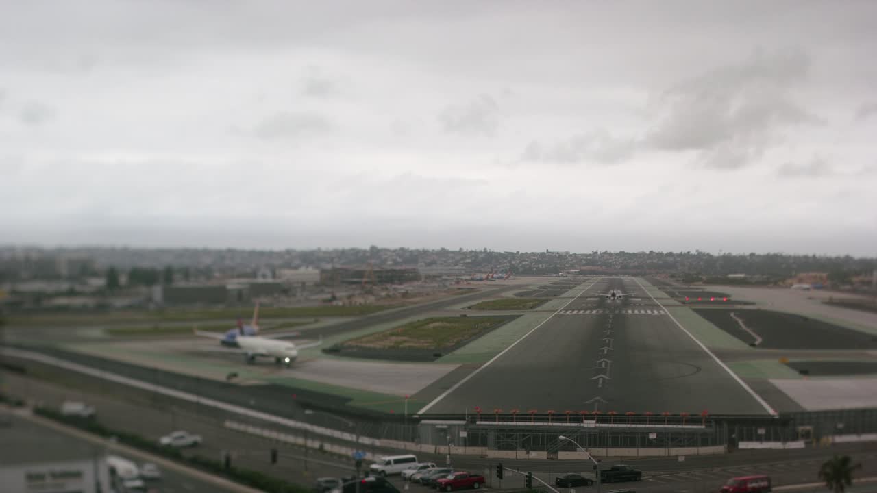 un timelapse de aviones despegando y aterrizando en el aeropuerto internacional de san diego, filmado con una lente de desplazamiento de inclinación para un efecto en miniatura