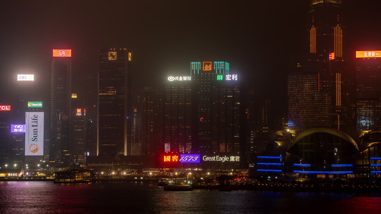 HONG KONG - 19 MARCH 2025 : Hong Kong Central city skyline filmed from across the harbour in kowloon with all the skyscrapers lit up at night advertisements