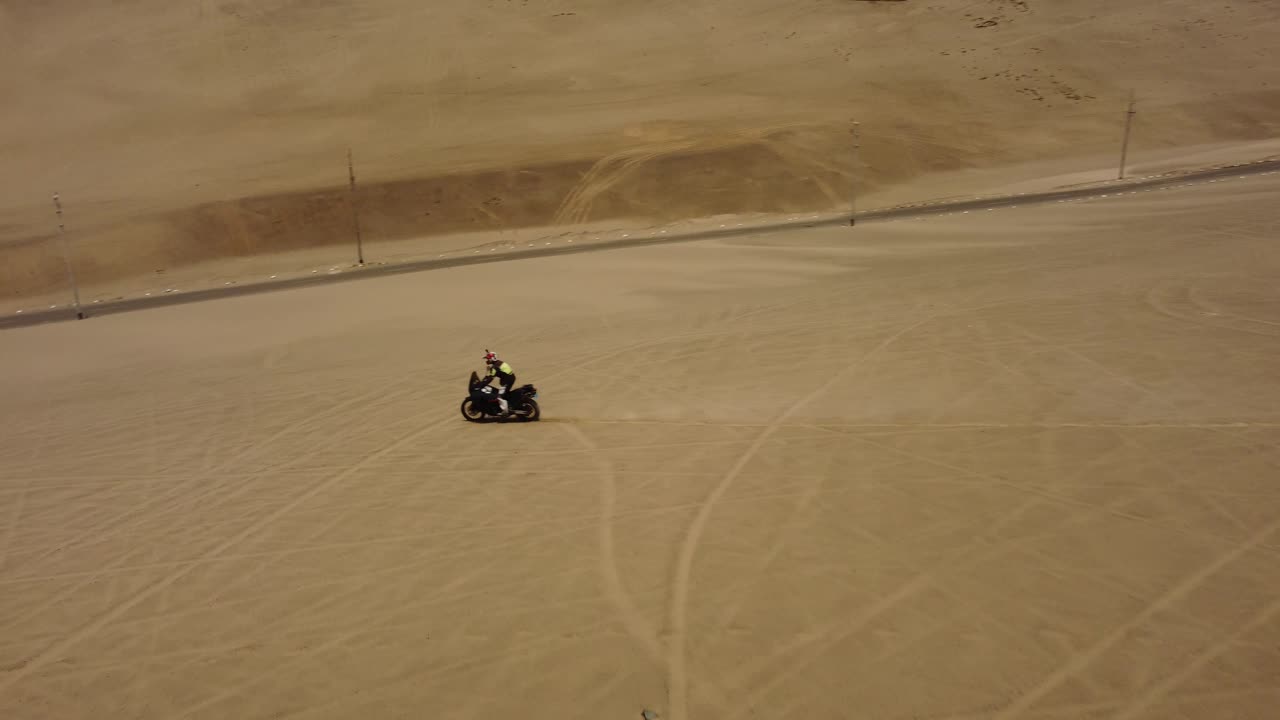 Una moto che sfreccia tra le dune del deserto