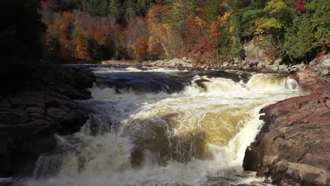 Stromschnellen,-Wasserfall-Im-Herbst,-Farbiger-Wald,-Niedrige-Sicht,-Rückwärtsflug