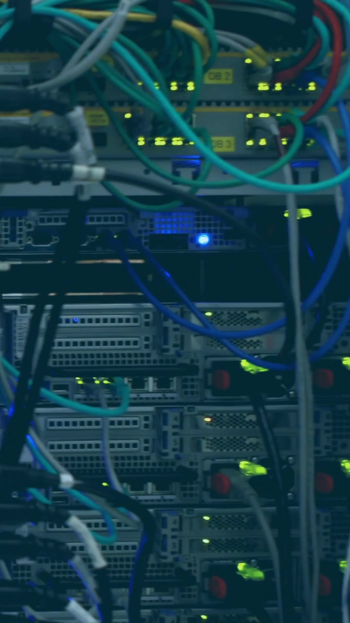 Vertical video: Camera panning across datacenter rack showing switches ports cables LEDs for audit