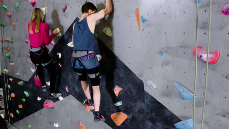 teenage boy and girl climbing indoors