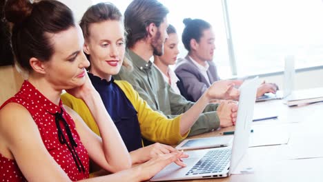 Smiling-business-team-interacting-with-each-other-in-conference-room