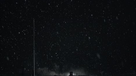 Winter-snowfall-at-night-snowing-on-city-street-in-street-light