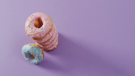 video of donuts with icing on purple background