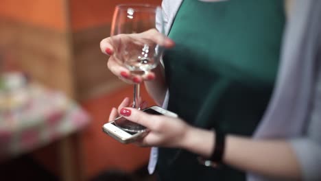 woman holding wine glass and phone