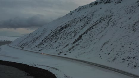 Supercar-driving-towards-the-camera-on-a-deserted-road-in-the-fjords-of-Northern-Norway-during-winter