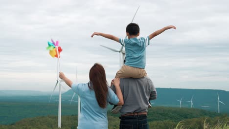 concept of progressive happy family enjoying their time at the wind turbine farm