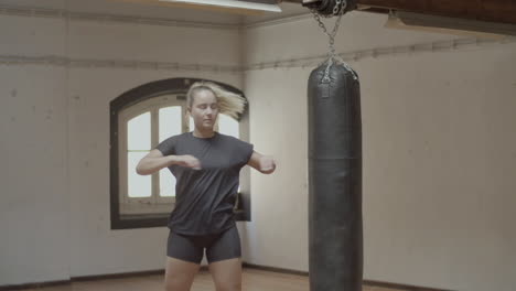 medium shot of woman warming up in gym before boxing training