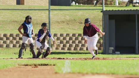 Diverse-group-of-female-baseball-players-playing-on-the-field,-happy-hitter-hitting-ball-and-running