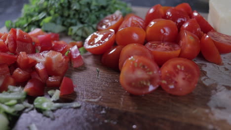 Slow-pan-left-to-right-of,-chopped-red-peppers,-tomatoes,-kale-and-zucchini--courgette-on-wooden-chopping-board