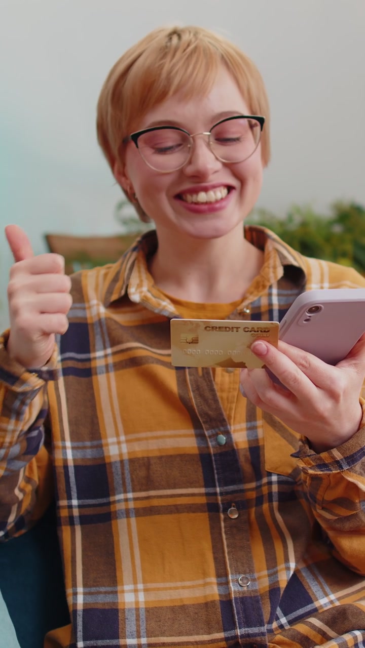 Young woman using credit bank card and smartphone transferring money purchases online shopping