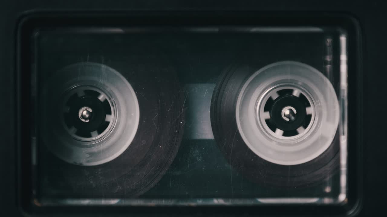 casete de audio transparente de época jugando en la cubierta de un viejo grabador de cinta