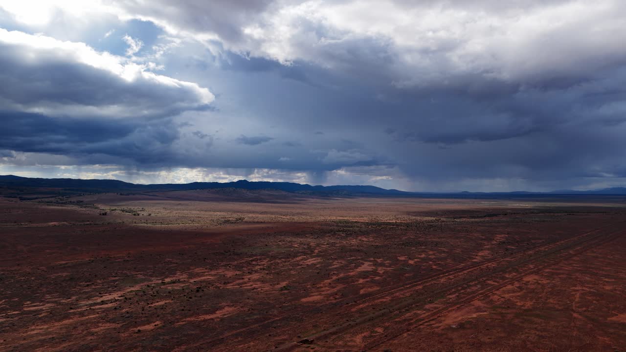 Veduta con drone di nuvole temporalesche che si formano sulle pianure rosse dell'outback nell'Australia Meridionale.