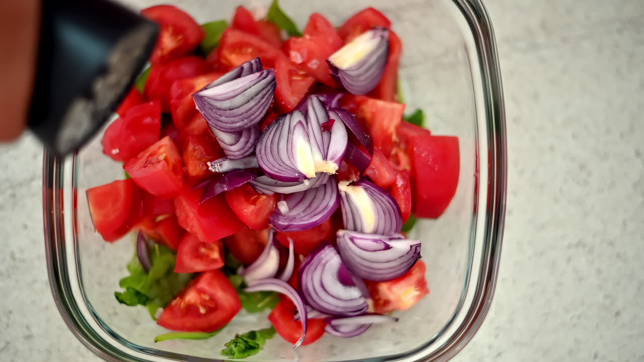 Chopping ripe tomatoes and slicing purple onions, this cozy kitchen showcases a vibrant salad made with fresh ingredients, perfect for any meal