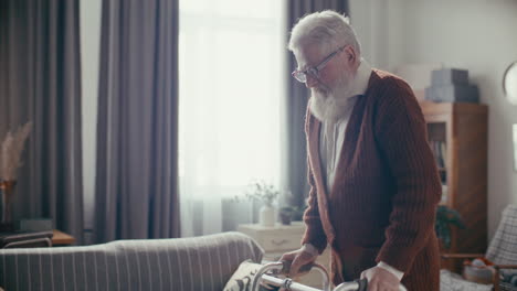 elderly man walking with help of walker through living room