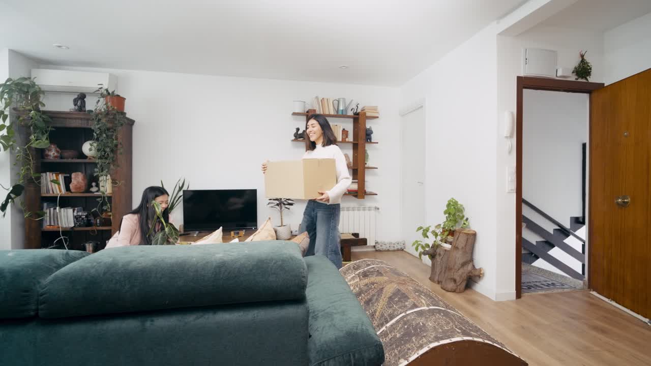 Happy Young Women Moving into New Home with Cardboard Boxes