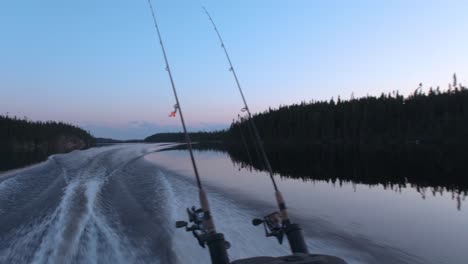 view from the back of a fishing boat speeding on a lake with a nice colourful sky