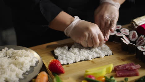 Close-up of Hands Preparing Sushi Rolls