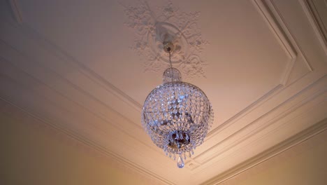 Slow-orbiting-shot-around-a-beautiful-crystal-chandelier-in-a-chateau