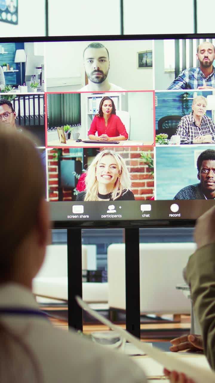 Vertical Video Diverse team of workers reviewing project updates together with shareholders