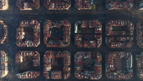 Symmetrical-square-blocks-of-buildings-in-urban-borough.-Fly-above-town-development-at-golden-hour.-Barcelona,-Spain