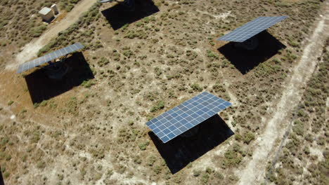 aerial view of solar panels farm in a desert place, orbital shot