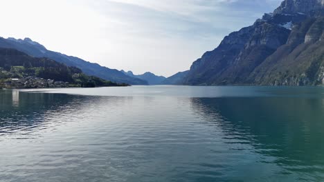 Vuelo-Aéreo-Lento-Sobre-La-Superficie-Reflectante-Del-Agua-Del-Lago-Walen-En-Suiza