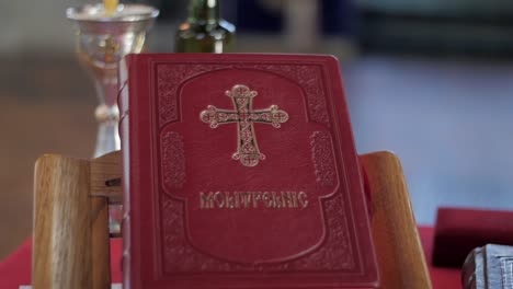 Handheld-shot-of-a-red-holy-book-in-a-church-setting