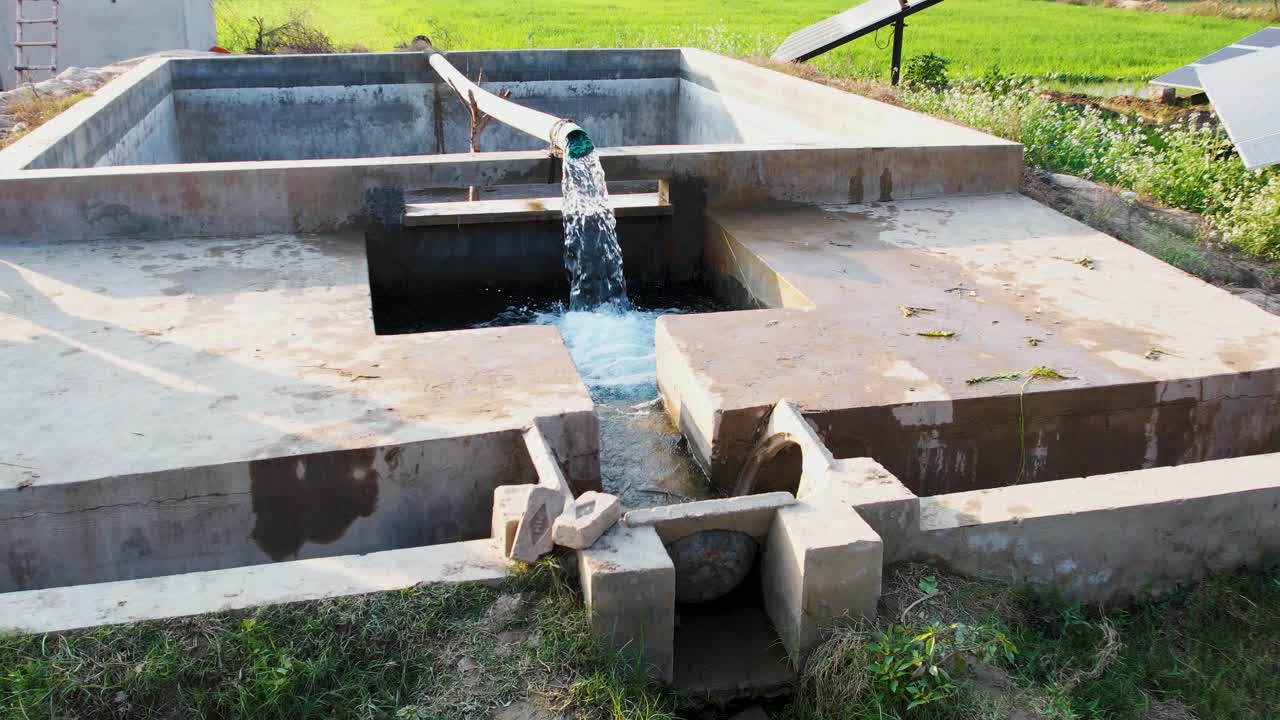 Water from a solar-powered tubewell flows into a concrete channel for crop irrigation. Punjab, Pakistan