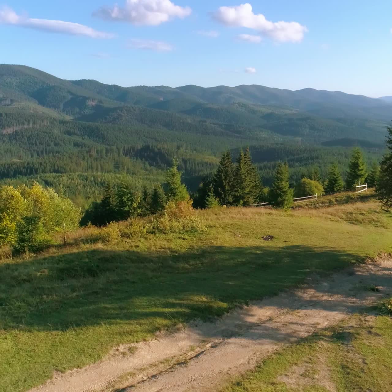 Amazing mountainous area in a sunny day. Flight over the green hill. Musician performing music on mountains background. Aerial view