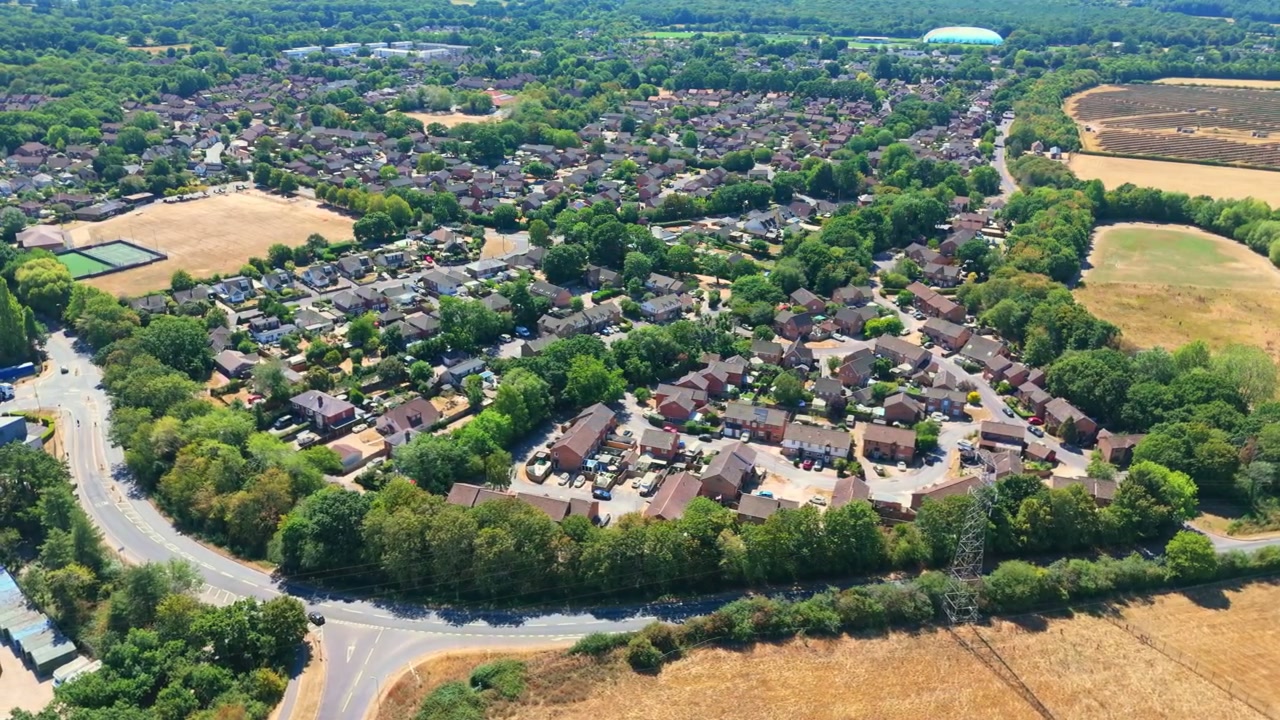 Marchwood is a Hampshire village on Southampton Water near the New Forest, featuring residential estates, local boatyards, and a major military port on sunny summers day with dry grass.